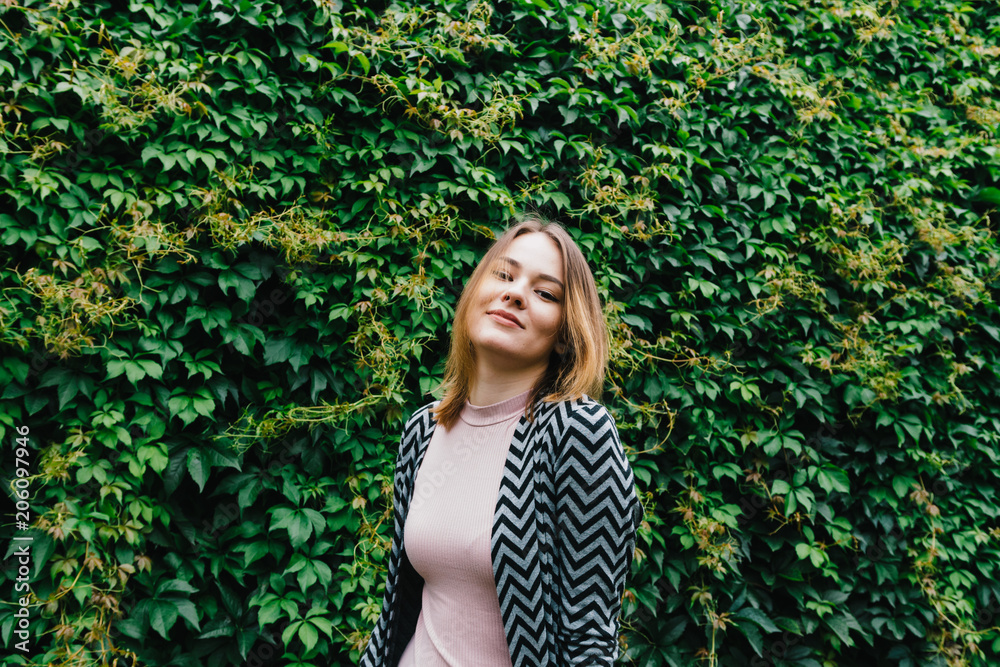 Portrait of a stylish woman against a green foliage background. Portrait of a stylish woman against a green foliage background.
