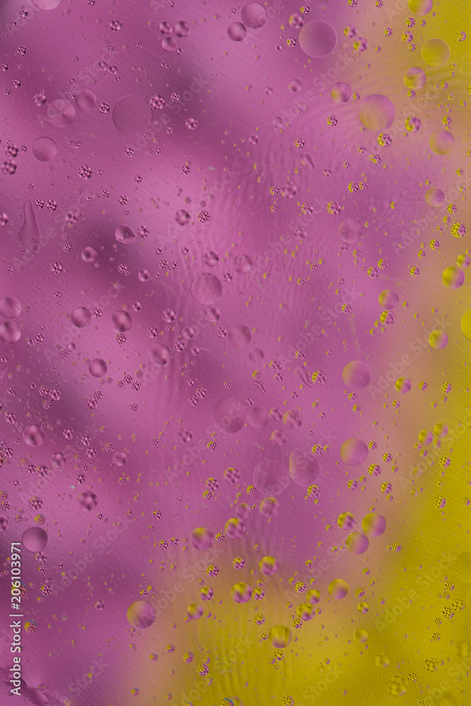 Liquid texture abstraction. Particles of oil and water with a strongly colored blurred background. The color of holiday. Explosion of liquid. Surrealism