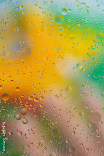 Liquid texture abstraction. Particles of oil and water with a strongly colored blurred background. The color of the holiday. Explosion of liquid