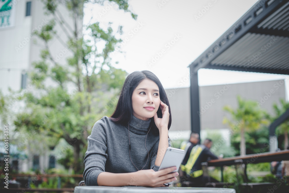 Fototapeta premium Portrait of young businesswoman use mobile phone while sitting in comfortable coffee shop during work break, charming happy female reading fashion news on cell telephone