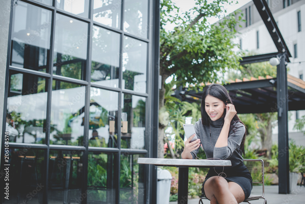 Portrait of young businesswoman use mobile phone while sitting in comfortable coffee shop during work break, charming happy female reading fashion news on cell telephone Portrait of young businesswoman use mobile phone while sitting in comfortable coffee shop during work break, charming happy female reading fashion news on cell telephone