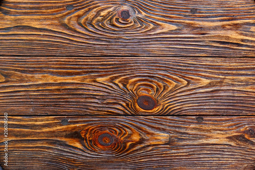 surface is very textured of old brushed boards covered with stain. Dark brown Wood background.