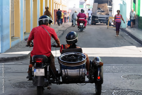 Santiago de Cuba, CUBA Couple riding in motorcycle with sidecar on the road ni Santiago de Cuba.