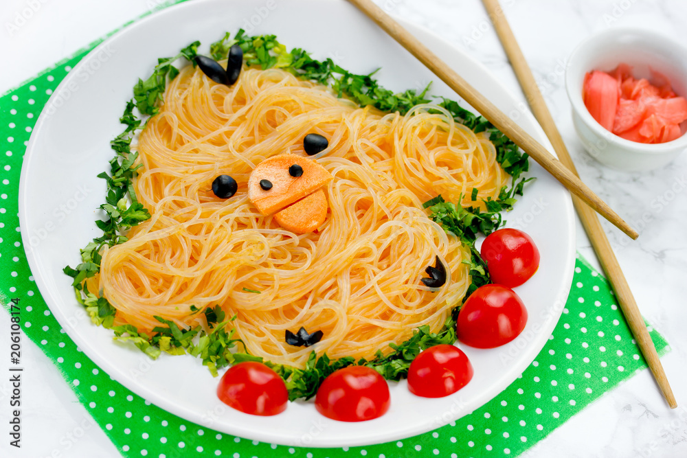 Fun food idea for kids - cute yellow chicken rice noodles funchoza with green onion and cherry tomatoes for healthy lunch