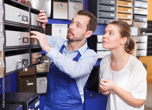 Worker helping woman choosing mailbox