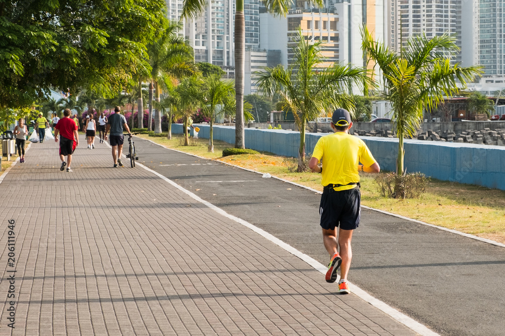 people running in public park with city background people running in public park with city background