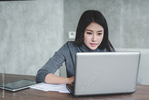 Young businesswoman working on laptop in her workstation.