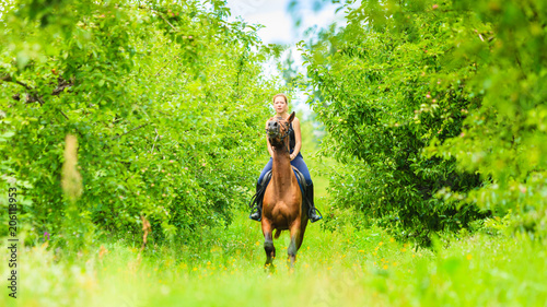 Young woman ridding on a horse © Voyagerix