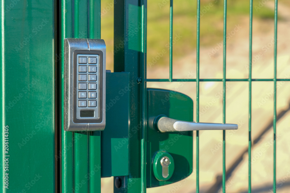 silver intercom on green fence on park entry silver intercom on green fence on park entry