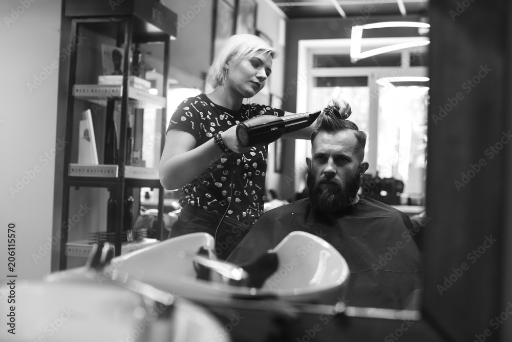 Stylish hairdresser cutting hair of client at barber shop. Beard man getting haircut at salon. Stylish hairdresser cutting hair of client at barber shop. Beard man getting haircut at salon.