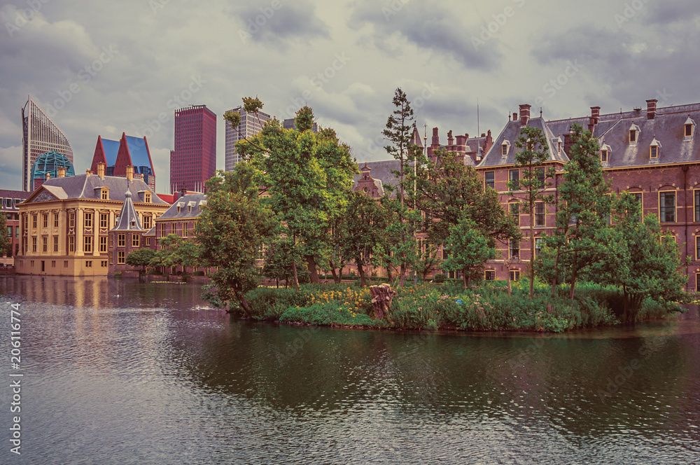 Hofvijver lake, Binnenhof (Gothic public buildings) and skyscrapers in The Hague. Important political center, is a mix of historic city with modernity. Western Netherlands. Retro vintage filter.