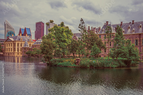 Hofvijver lake, Binnenhof (Gothic public buildings) and skyscrapers in The Hague. Important political center, is a mix of historic city with modernity. Western Netherlands. Retro vintage filter.