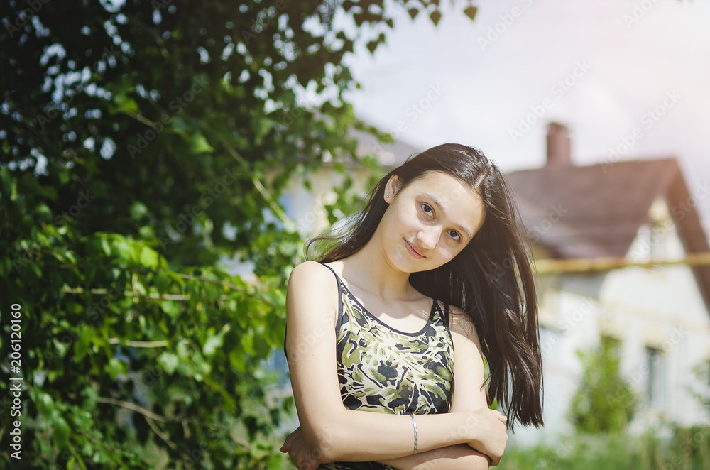 Beautiful teen girl on a green tree background. Beautiful teen girl on a green tree background.