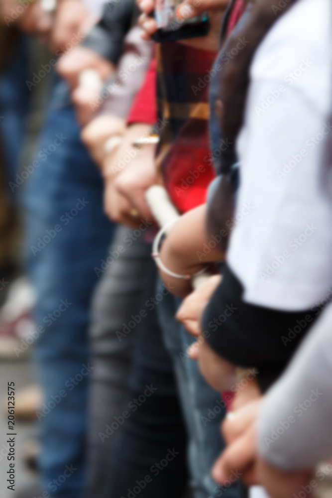 blur image of various people pulling rope together, closeup of hands. Teamwork. Unity concept. Selective focus