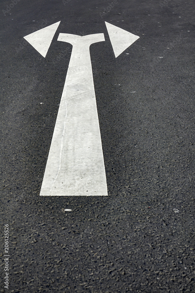 Double pointing arrow painted on a street Double pointing arrow painted on a street
