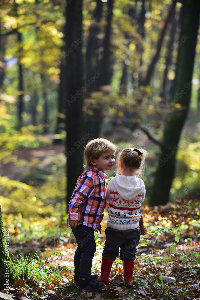 Friends play in autumn forest. Friends and child friendship, love and trust.
