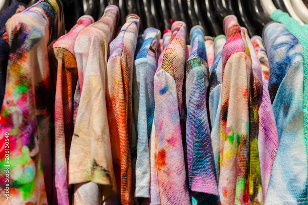Close-up of colorful Clothes on black Plastic Hangers