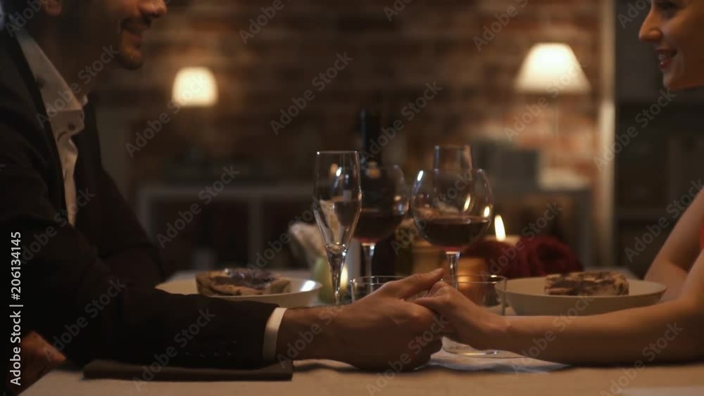 Romantic couple dining together and holding hands