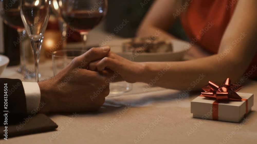 Romantic couple dining together and holding hands
