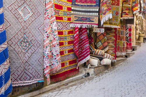 colored carpets with ornaments on the wall in old city in Morocco
