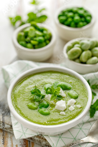 Vegetable cream soup. Broad bean soup sprinkled with  fresh mint and Feta cheese. Delicious and nutritious vegetarian food. Healthy eating concept.