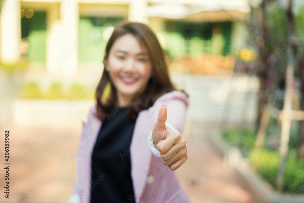 thumbs up for Asian businesswomen ,she smiles and Starts of a perfect partnership, press like button.Successful business people with  good luck thumbs-up concept.