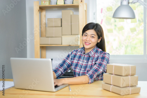 Shipping shopping online ,young start up small business owner writing address on cardboard box at workplace.businesswomen entrepreneur SME or freelance asian woman working with box at home