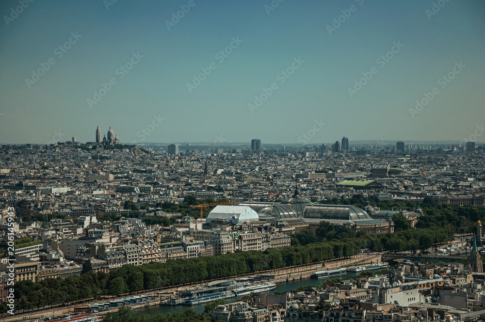 Skyline, River Seine, greenery and buildings under blue sky, seen from the Eiffel Tower in Paris. Known as the “City of Light”, is one of the most impressive world’s cultural center. Northern France.