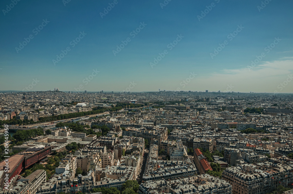 Skyline, River Seine, greenery and buildings under blue sky, seen from the Eiffel Tower in Paris. Known as the “City of Light”, is one of the most impressive world’s cultural center. Northern France.