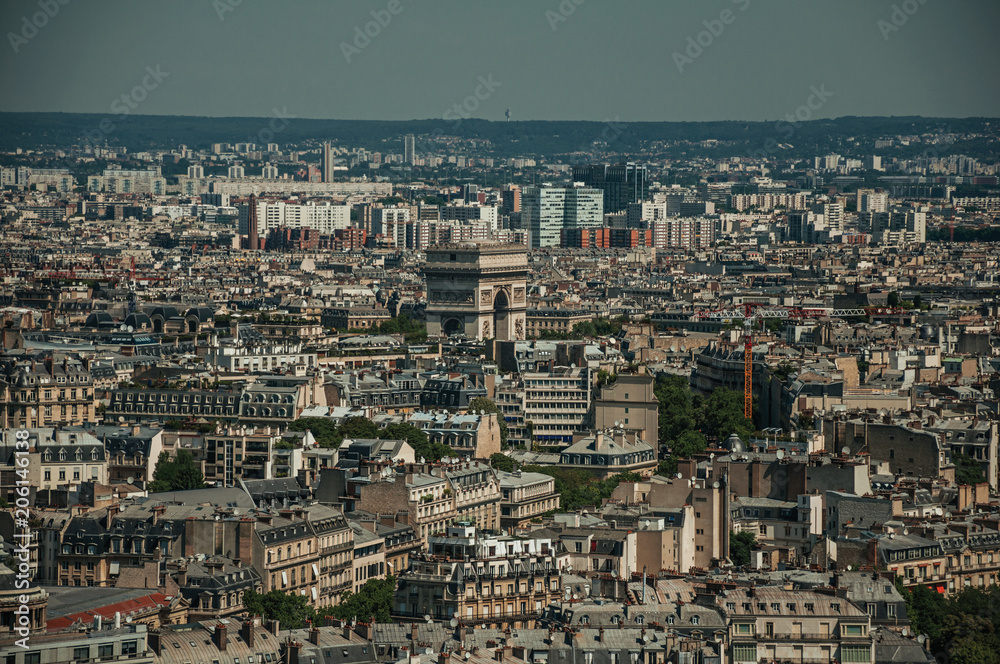 Skyline, the Arc de Triomphe and buildings under blue sky, seen from the Eiffel Tower in Paris. Known as the “City of Light”, is one of the most impressive world’s cultural center. Northern France.