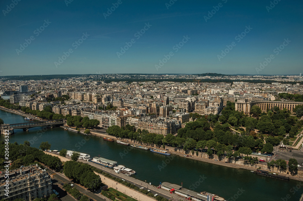 Skyline, River Seine, greenery and buildings under blue sky, seen from the Eiffel Tower in Paris. Known as the “City of Light”, is one of the most impressive world’s cultural center. Northern France.