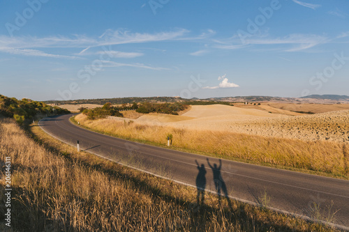 scenic view of beautiful Tuscany fields  empty road and peoples shadow  Italy
