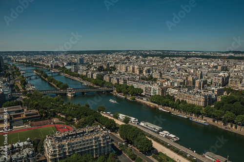 Skyline, River Seine, greenery and buildings under blue sky, seen from the Eiffel Tower in Paris. Known as the “City of Light”, is one of the most impressive world’s cultural center. Northern France.