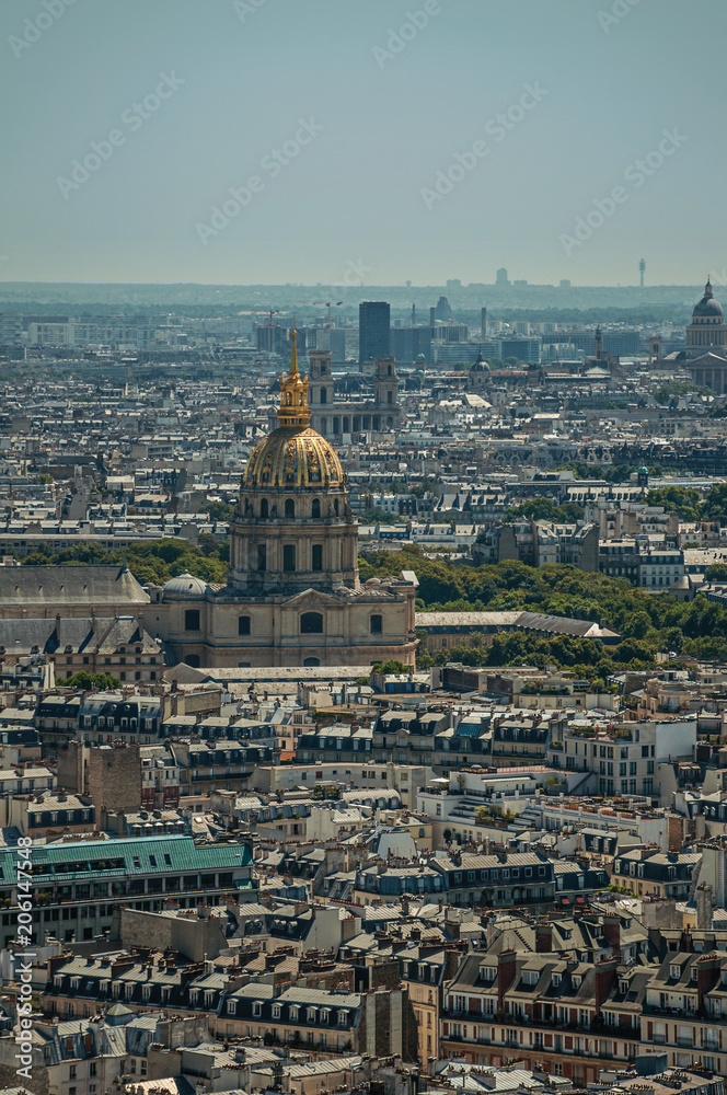 Skyline, buildings and Les Invalides dome in a sunny day, seen from the Eiffel Tower in Paris. Known as the “City of Light”, is one of the most impressive world’s cultural center. Northern France.