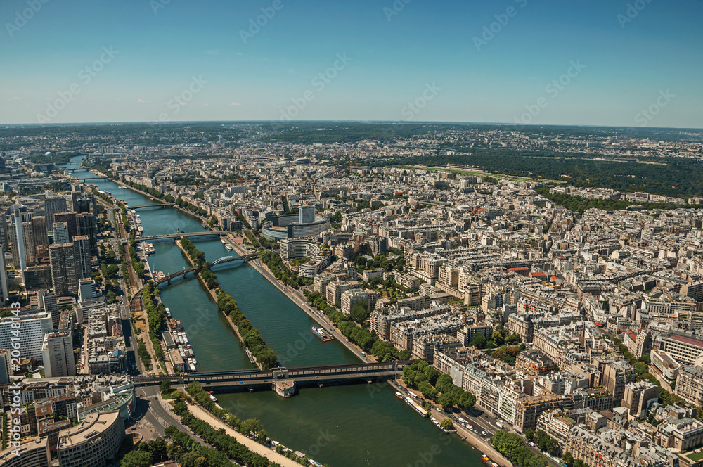 River Seine, greenery and buildings in a sunny day, seen from the Eiffel Tower top in Paris. Known as the “City of Light”, is one of the most impressive world’s cultural center. Northern France.