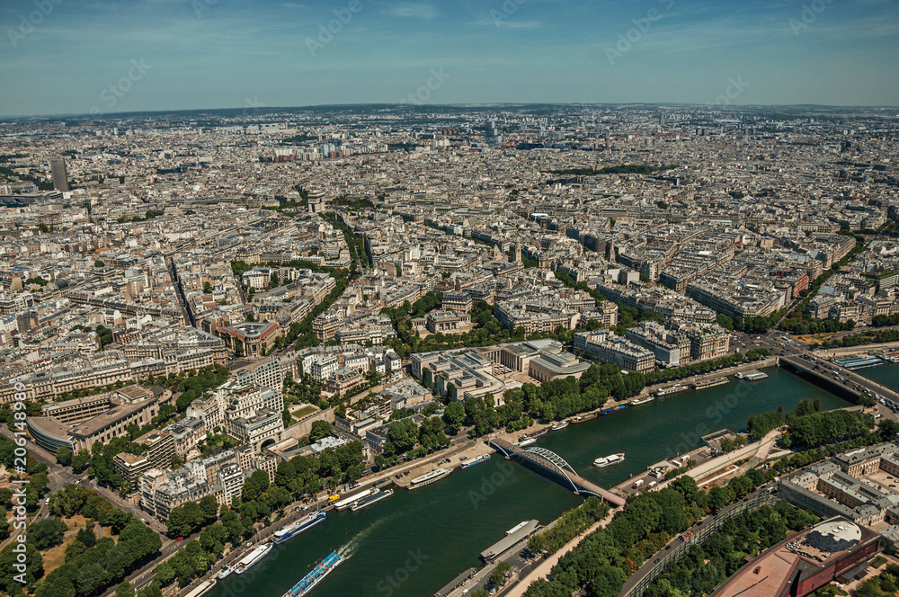 Seine River, greenery and buildings in a sunny day, seen from the Eiffel Tower top in Paris. Known as the “City of Light”, is one of the most impressive world’s cultural center. Northern France.