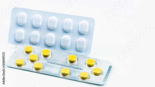 Ergotamine drug interactions concept. Yellow tablet pills and white blister pack. Migraine headache treatment with pills. Pharmaceutical industry. Background for health topic in working woman and man  photo