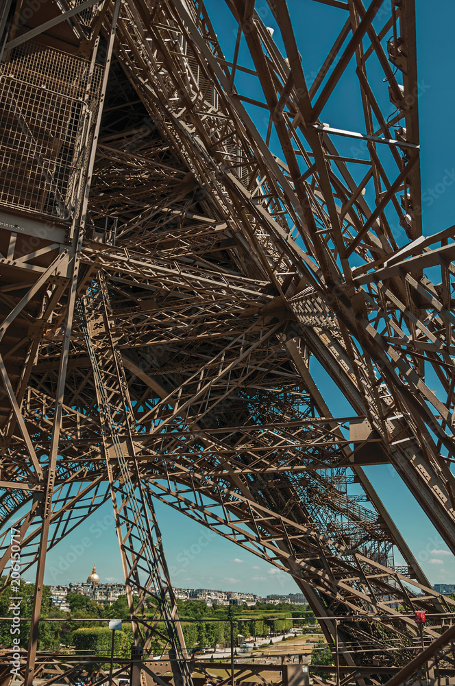 View of internal iron structure of the Eiffel Tower, with sunny blue sky in Paris. Known as the “City of Light”, is one of the most impressive world’s cultural center. Northern France.
