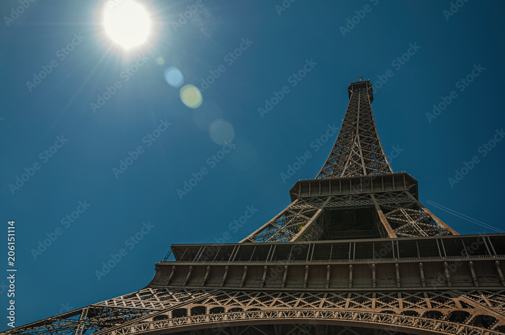 Overview of the stunning Eiffel Tower all made of iron with blue sky and sunshine in Paris. Known as the “City of Light”, is one of the most impressive world’s cultural center. Northern France.