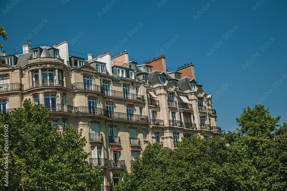 Building amidst trees and sunny blue sky with Parisian architecture of Paris. Known as the “City of Light”, is one of the most impressive world’s cultural center. Northern France.