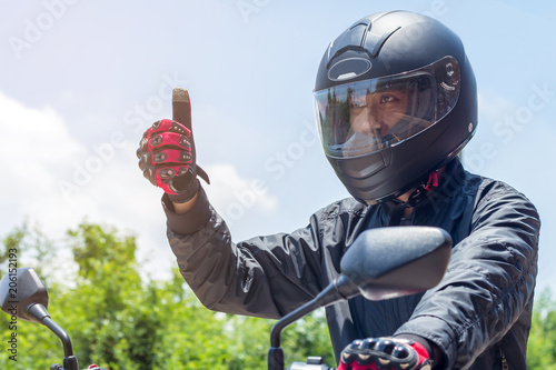 Fotografia Man in a Motorcycle with helmet and gloves is an important protective clothing f