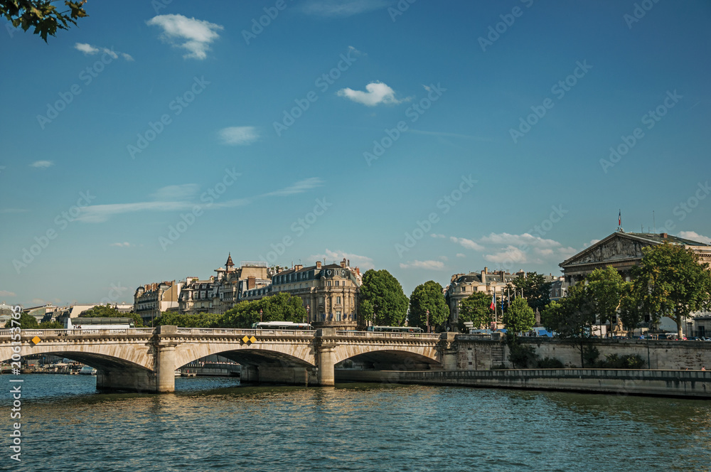 Buildings, trees and bridge of La Concorde on the Seine River at sunset in Paris. Known as the “City of Light”, is one of the most impressive world’s cultural center. Northern France.