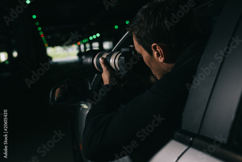 rear view of male paparazzi spying by camera with object glass from his car © LIGHTFIELD STUDIOS