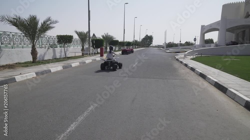 Girl teenager rides on ATV on the road photo