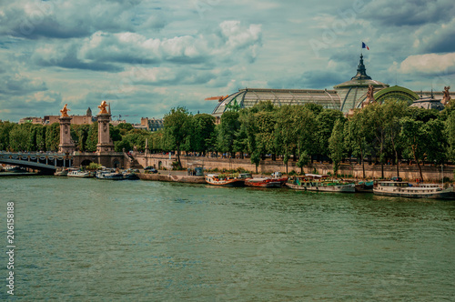 Boats at Seine River, Alexandre III bridge and Grand Palais building in Paris. Known as the “City of Light”, is one of the most impressive world’s cultural center. Northern France. Retouched photo