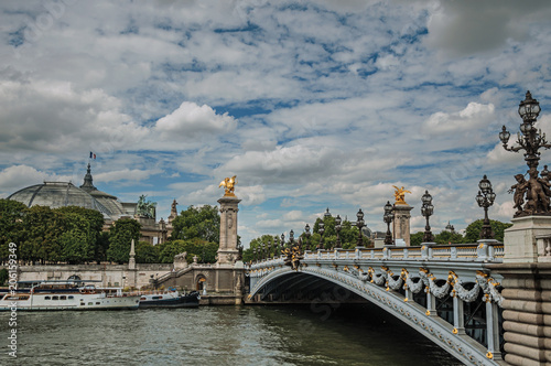 Alexandre III bridge, Grand Palais building and boats anchored at Seine River bank in Paris. Known as the “City of Light”, is one of the most impressive world’s cultural center. Northern France.