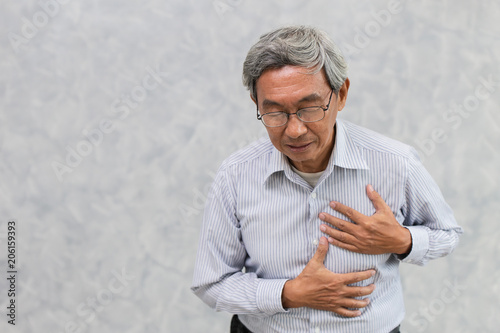 Asian Elder suffer from Chest pain from Heart Attack or Stroke with space for text.