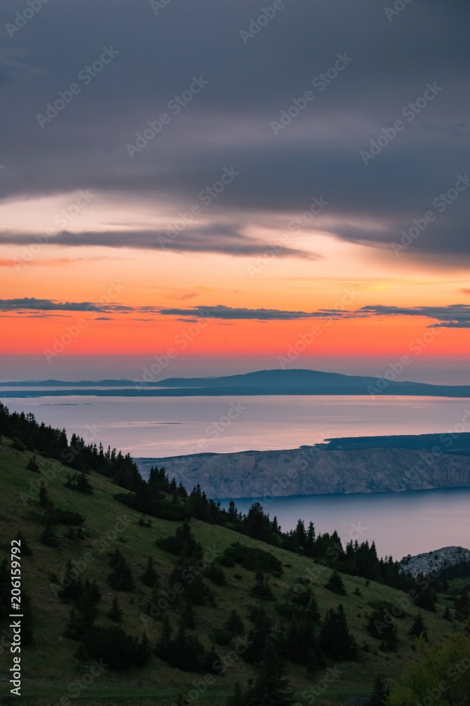Obraz premium Landscape view of Croatian islands in the Adriatic sea from the Velebit mountain during a beautiful colorful sunset, national park Velebit in Croatia