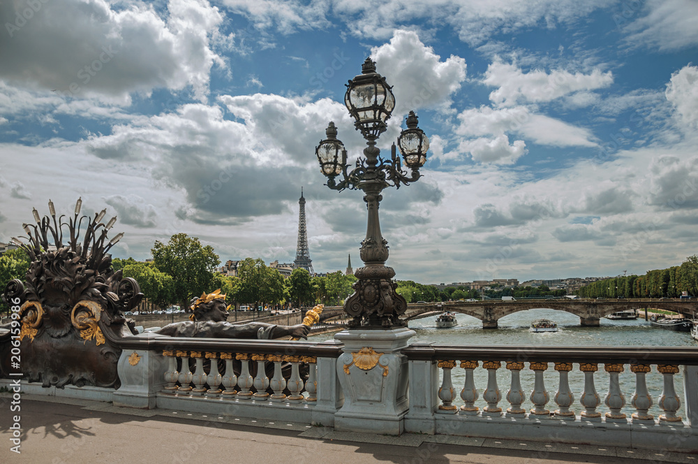 Golden statue and lighting post adorning the Alexandre III bridge over the Seine River and Eiffel Tower in Paris. Known as one of the most impressive world’s cultural center. Northern France.