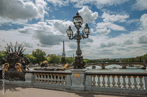 Golden statue and lighting post adorning the Alexandre III bridge over the Seine River and Eiffel Tower in Paris. Known as one of the most impressive world’s cultural center. Northern France. photo